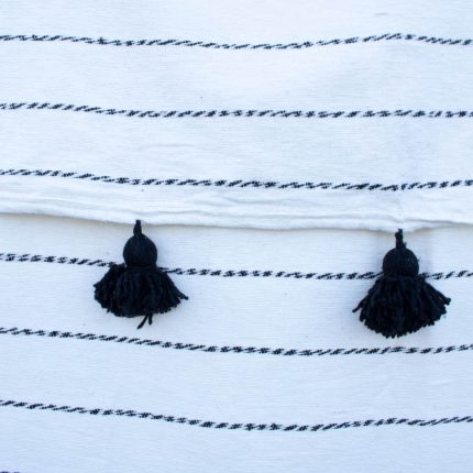 Manta Blanca con lineas negras y pompones color negro