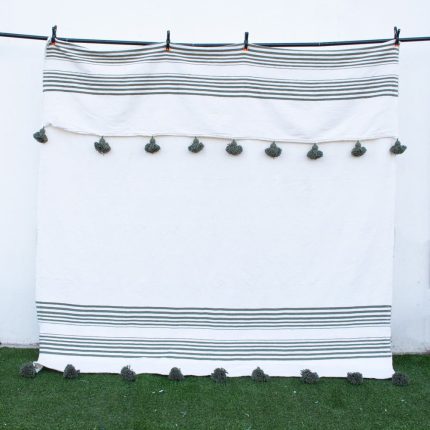 Manta blanca con lineas y pompones verdes