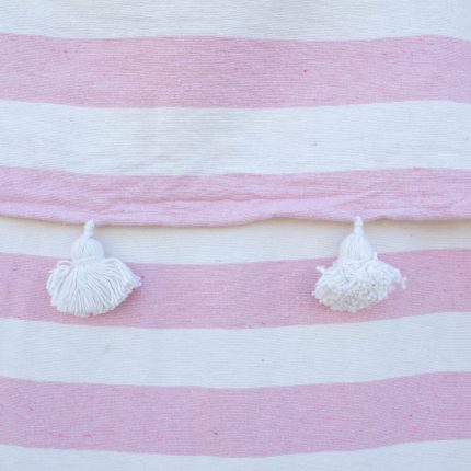 Manta blanca con lineas rosadas y pompones blancos